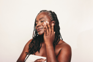 woman smiling rubbing cream into face